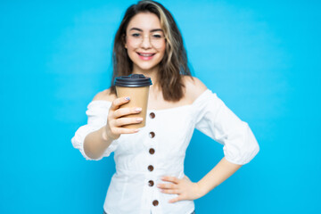 Fototapeta premium Emotional portrait of woman drink coffee to go on blue background