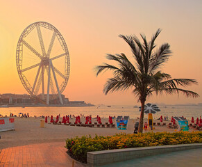 Dubai, UAE - May 08, 2018: Dubai Marina promenade at sunset. Ferris wheel, Dubai marina beach,...