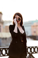 Woman in black pantsuit walks on promenade