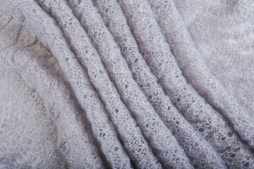 Fototapeta na wymiar top view on folded openwork binding gray, knitted, woolen shawl with pattern