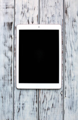 White tablet on the wooden board