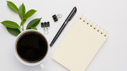 Work from home  with coffee cup, pen and notebook memo  on white background,top view