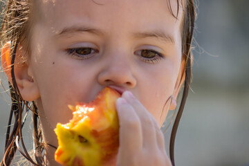 little girl eating a peach