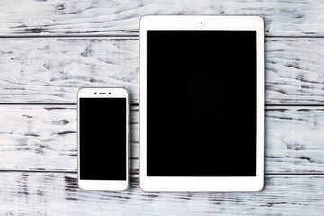 Smartphone and tablet on the wooden board