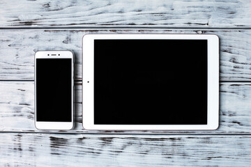 Smartphone and tablet on the wooden board