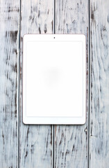 White tablet on the wooden board
