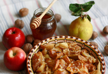 Baked apples with honey, quince and walnuts on the table