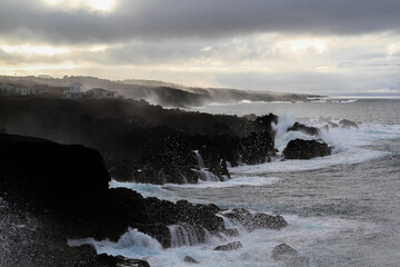 Wild seascape at Pico, Azores, Portugal, with black lava rocks on the coast