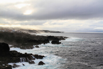 Naklejka na ściany i meble Wild seascape at Pico, Azores, Portugal, with black lava rocks on the coast