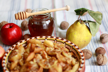 Baked apples with honey, quince and walnuts on the table