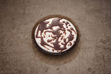 Jelly dessert with chocolate glaze on a cement background