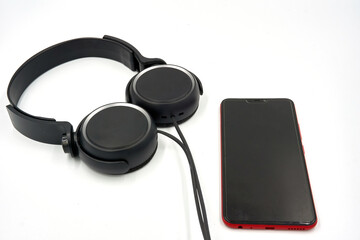 Headphones and mobile phone on white background