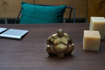The sumo wrestler statue in bronze on a wooden background