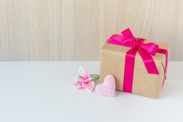 Happy Women's Day, Happy Mother's Day, Happy Valentine's Day and Happy Birthday. Have a flower, a crochet heart, a beautiful gift wrapped in a pink ribbon. White background. Copy space.