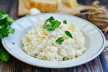 Italian creamy  cheese risotto with parmesan cheese and fresh basil on rustic background