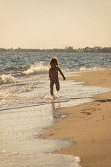 little girl runs in the shallows