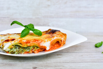   Delicious Home made Lasagna  with minced meat,tomato sauce and spinach  on a wooden rustic  background.Home made italian meal