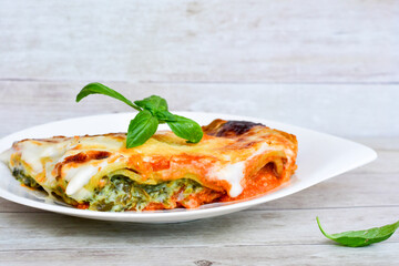   Delicious Home made Lasagna  with minced meat,tomato sauce and spinach  on a wooden rustic  background.Home made italian meal