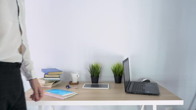 One business man wear white shirt, gray pants, holds out hand, wants say hello in office. Employee refuses to greet, complies safety rules, social distance. People worker don not handshake close up.