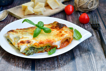   Delicious Home made Lasagna  with minced meat,tomato sauce and spinach  on a wooden rustic  background.Home made italian meal