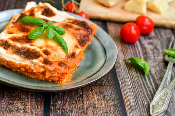   Delicious Home made Lasagna bolognese  with minced meat,tomato sauce and spinach  on a wooden rustic  background.Home made italian meal