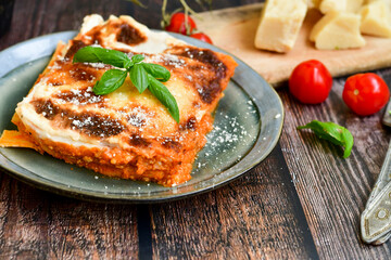   Delicious Home made Lasagna  with minced meat,tomato sauce and spinach  on a wooden rustic  background.Home made italian meal