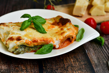   Delicious Home made Lasagna  with minced meat,tomato sauce and spinach  on a wooden rustic  background.Home made italian meal