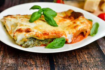   Delicious Home made Lasagna  with minced meat,tomato sauce and spinach  on a wooden rustic  background.Home made italian meal