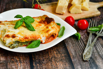   Delicious Home made Lasagna  with minced meat,tomato sauce and spinach  on a wooden rustic  background.Home made italian meal