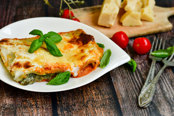   Delicious Home made Lasagna  with minced meat,tomato sauce and spinach  on a wooden rustic  background.Home made italian meal