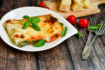   Delicious Home made Lasagna  with minced meat,tomato sauce and spinach  on a wooden rustic  background.Home made italian meal