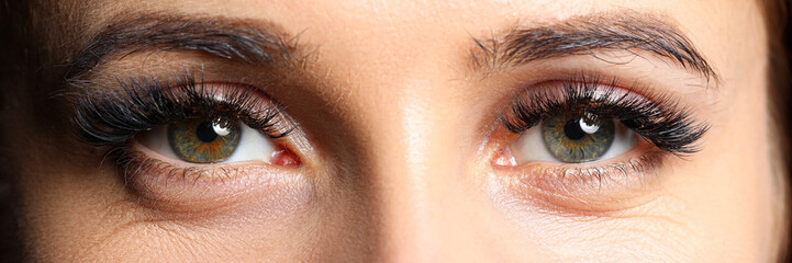 Pair of beautiful female green colored eyes with eyelashes extensions