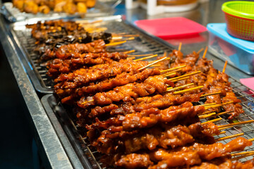 Asian food. A counter with mini kebabs of chicken skin and meat at a nightly street food market.