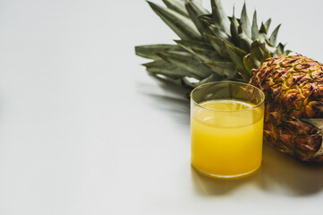 fresh pineapple juice near cut delicious fruit on white background