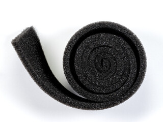 Black sponge sheet roll in a circle as a background. Top view
