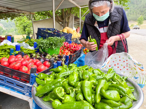  Old woman buying  green pepper at market