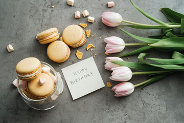 Flat Lay Background of Fresh Tulips, Yellow French Macarons and Note 