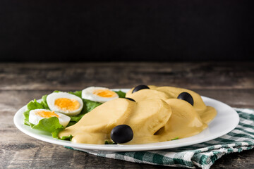 Traditional Peruvian papa a la huancaina on wooden table