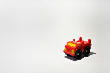 Small red plastic toy truck on white background
