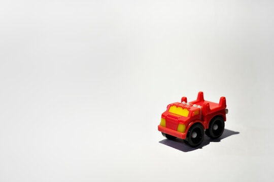 Small red plastic toy truck on white background