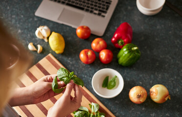 Anonymous female following online recipe preparing dinner