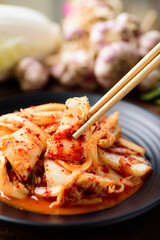 Kimchi cabbage on plate eating by chopsticks, Korean food