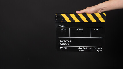 Hand is holding yellow and black color movie slate.It is used in video production and film industry...