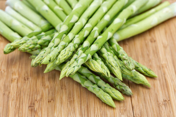 Heap of asparagus sprouts on rustic wooden background