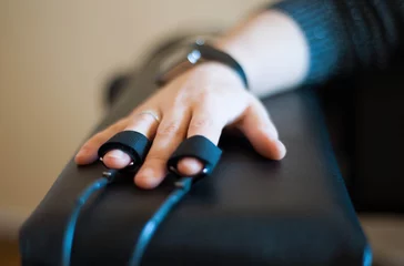 Fotobehang woman's hand in a lie detector apparatus close-up © Olena