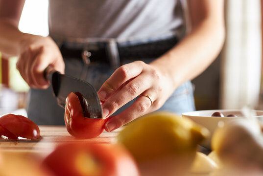 Close-up Of Woman Slicing A Tomato