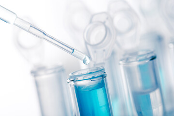 microbiological pipette in the genetic laboratory. study of a virus or vaccination. blue tinted.
