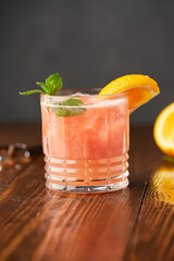 Grapefruit and orange smoothie coctail on grey wooden background. Refreshing drinks