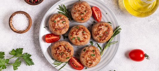 Fototapeta na wymiar Fresh chicken cutlets with tomatoes and rosemary