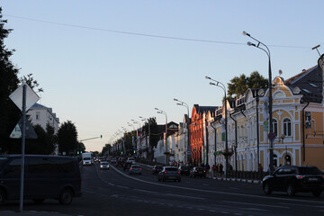 Street in the city. There are cars on the road and houses on either side of it. Roads in Russia.